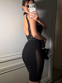 Person wearing a black sheer dress taking a mirror selfie. #color_black