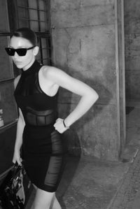 Person wearing a black dress with cut-out design in an urban setting #color_black