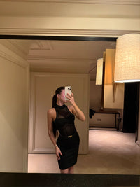 Person taking a mirror selfie wearing a black dress in an indoor setting. #color_black 